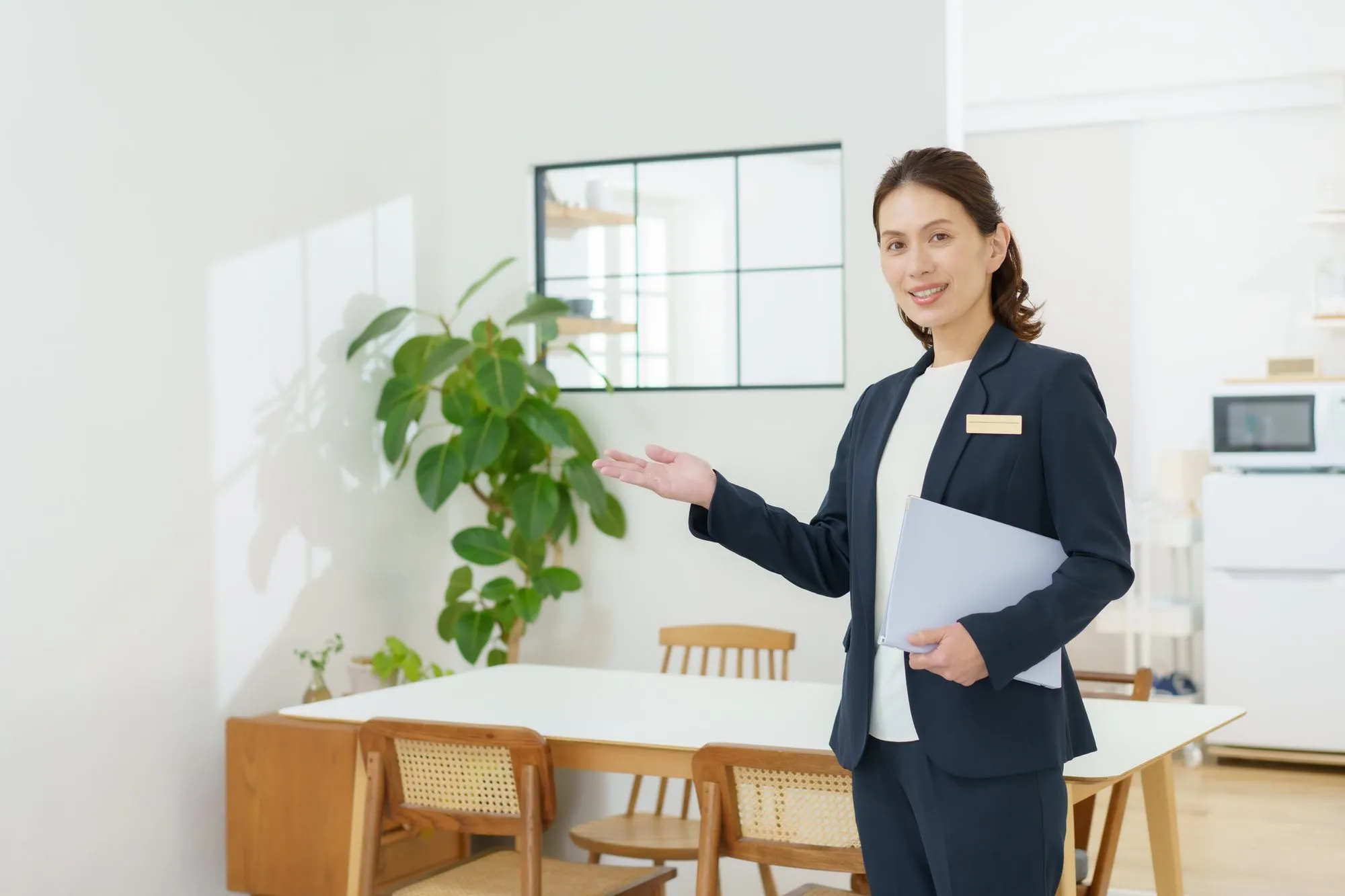 ダイニングで、担当者が資料を持ってご案内している場面